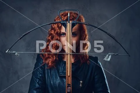 Redhead female holds crossbow. Stock Photos