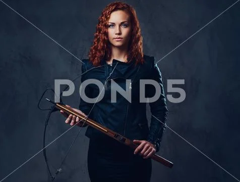 Redhead female holds crossbow. Stock Photos