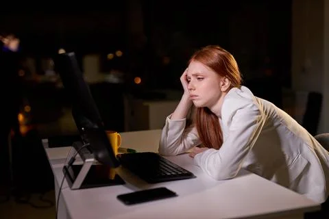 Redhead female thinks when will she go home after work, want to sleep and have Stock Photos