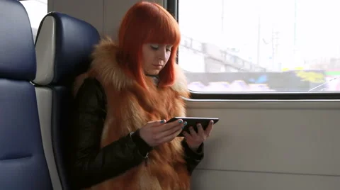 Redhead girl reads an sms in the train Stock Footage 52461853