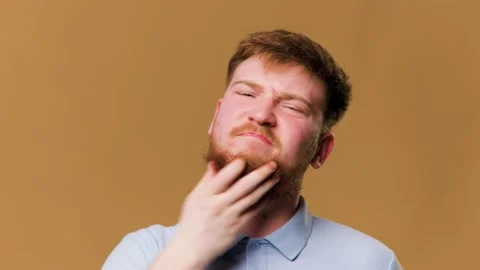 A redhead guy in a studio shot, suffering from an Stock Footage 234690792