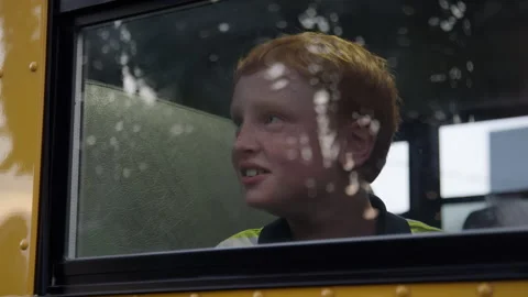 Redhead kid looking out school bus window Stock Footage 345306895