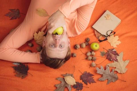 Redhead Man are getting ready for autumn sale. Red-haired man lies on an orange Fotos Stock