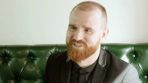 Redhead man with a beard drinking beer and talking with friends in a pub. 4K 動画素材 92375559