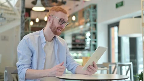 Redhead Man doing Video Chat on Tablet in Cafe Stock Footage 125861875