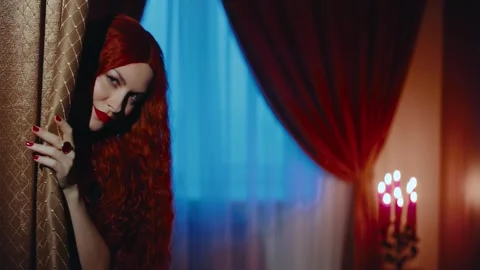 Redhead medieval witch beauty gothic woman hand opens curtain evil eyes looking Stock Footage 311946387