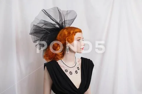 Redhead woman with unusual appearance in black dress and veil on the head and Stock Photos