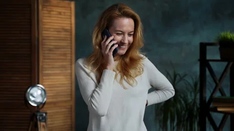 Redhead woman while standing in loft apartment talking on phone with her friend Stock Footage 162126877