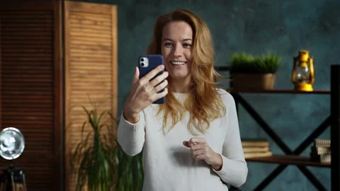 Redhead woman while standing in loft apartment talking on phone with her friend Stock Footage 162192417