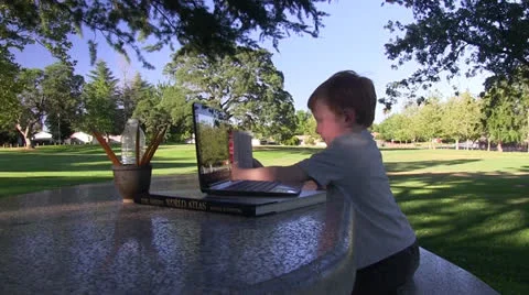 Redheaded boy with computer in park Stock Footage 24897302