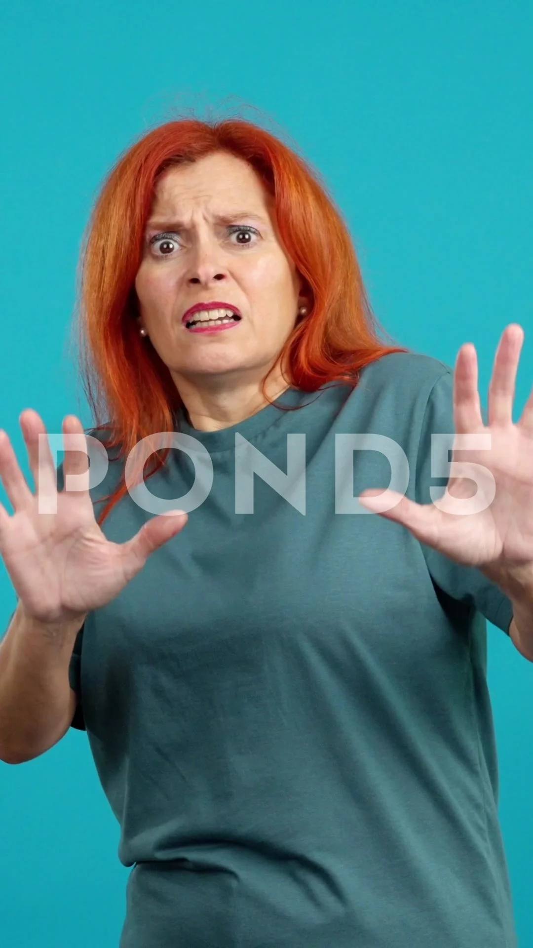 Redheaded mature woman gesturing with the hands in fear