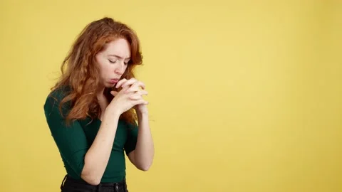 Redheaded woman looking up while praying with folded hands Video stock 237542049