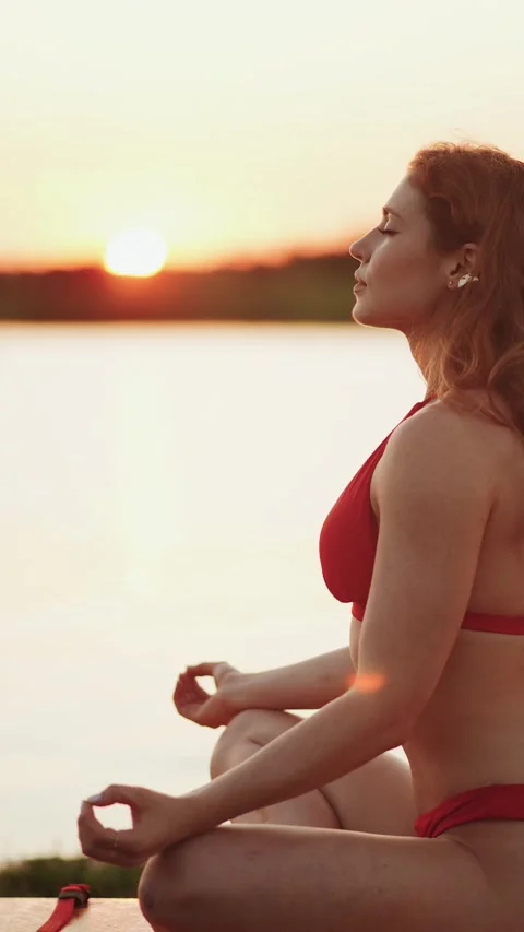 Redheaded woman in a red bikini posing on a paddleboard at sunset Stock Footage 341468051