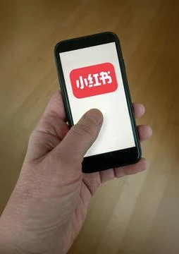 Rednote app on smartphone screen held in hand. Stock Photos