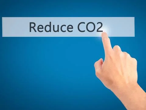Reduce CO2 - Hand pressing a button on blurred background concept . Business, Stock-Fotos