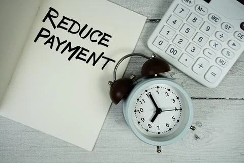 Reduce Payment text on paper notebook page with alarm clock and calculator .. 写真素材