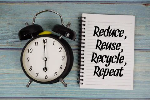 Reduce, Reuse, Recycle, Repeat text written on notepad with alarm clock on .. Stock Photos