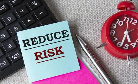 REDUCE RISK - words on paper for notes on the background of calculator, pens Stock Photos