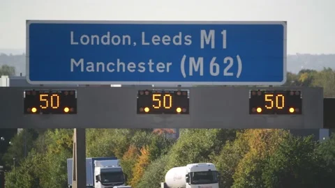 Reduced speed limit warning signs on gantry on the A!/M1 link road leeds uk Stock Footage 213564582