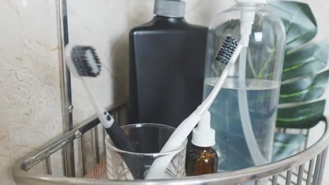Reducing visual clutter. Toothbrushes and toiletries on a bathroom shelf, Video stock 338389711