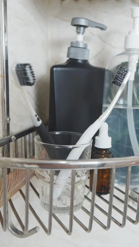 Reducing visual clutter. Toothbrushes and toiletries organized on a bathroom Video stock 338392726