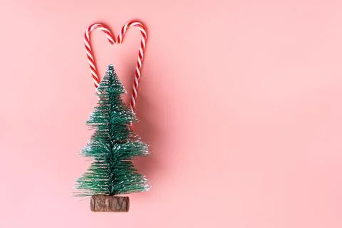 Ree Christmas tree with candy cane on pastel pink studio background Stock Photos