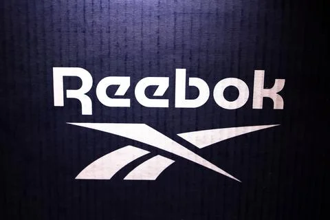 Reebok logo, on a blue background in neon light Stock Photos