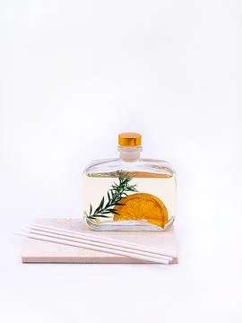 Reed diffuser with cinnamon and orange on white background Stock Photos