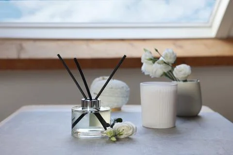 Reed diffuser, scented candle and eustoma flowers on gray marble table Stock Photos