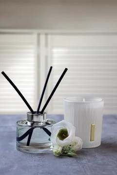 Reed diffuser, scented candle and eustoma flowers on gray marble table Stock Photos