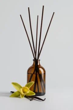 Reed diffuser with vanilla sticks in a brown glass bottle and vanilla flower  Stock Photos
