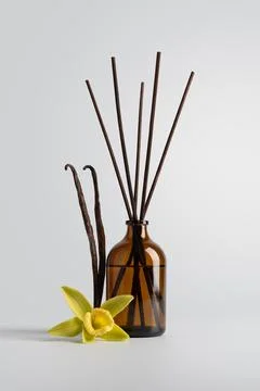 Reed diffuser with vanilla sticks in a brown glass bottle and vanilla flower  Stock Photos