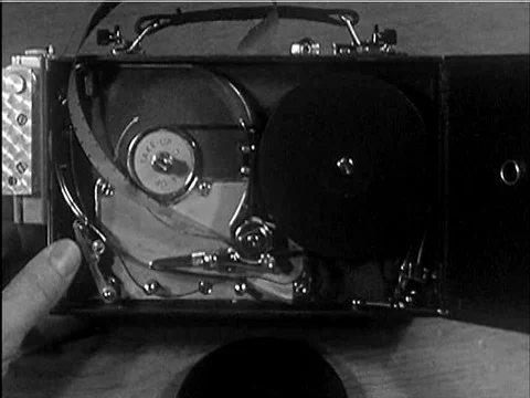 A reel of film is threaded into a Cine-Kodak Special 16mm movie camera, in 1955. Stock Footage 83226903