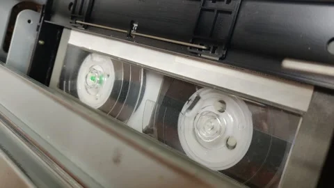 REELS TURNING INSIDE VIDEO CASSETTE / TAPE Stock Footage 256730887