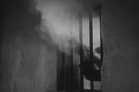 Reenactment of man shooting through prison bars, 1930s 스톡 동영상 90727823