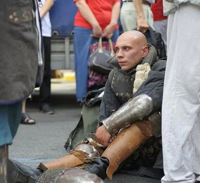 Reenactor dressed in armor of an Old Russian footman taking break after fight Stock Photos