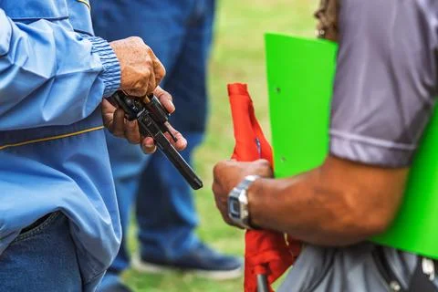 Referee checking starting pistol revolver for sports competition. .Sports o.. Stock Photos