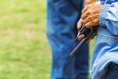 Referee checking starting pistol revolver for sports competition. .Sports o.. Stock Photos