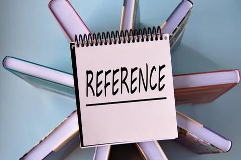 REFERENCE - word on a yellow piece of paper on the background of books Stock Photos