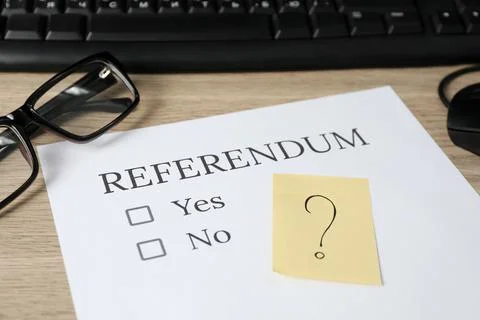 Referendum ballot, glasses and sticky note with question mark on wooden table Stock Photos