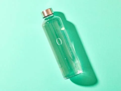 Refillable drinking water bottle on mint green background Stock Photos