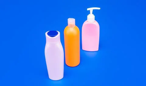 Refillable plastic toiletry packaging containers HDPE multicolor blue background Stock Photos