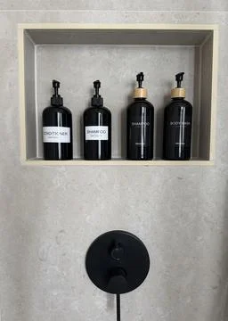 Refillable shampoo, conditioner and body wash pump bottles arranged Stock Photos