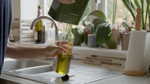 Refilling a Bottle of Olive Oil Stock Footage 116784601