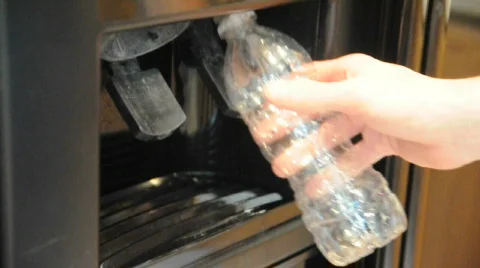 Refilling an empty water bottle from a refrigerator Stock Footage 481748