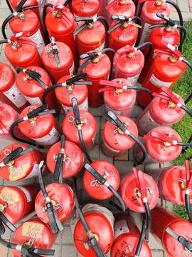 Refilling fire extinguishers. Many Red Fire Extinguisher on the Ground in a.. Stock Photos