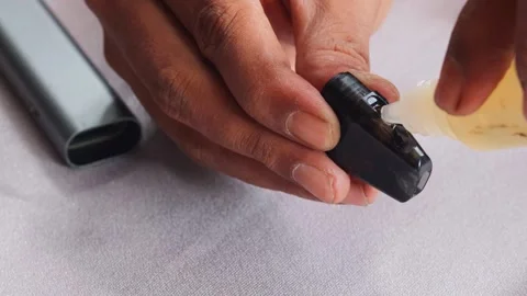 Refilling vape pod with e liquid Stock Footage 340596716