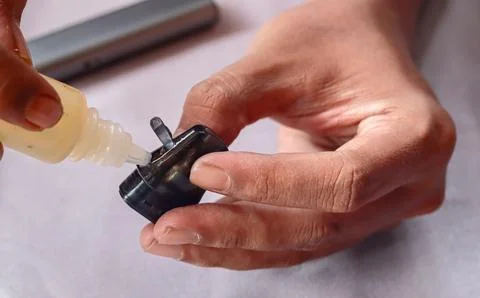 Refilling vape pod with e liquid Stock Photos
