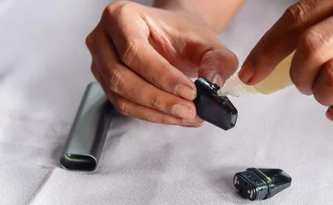Refilling vape pod with e liquid Stock Photos
