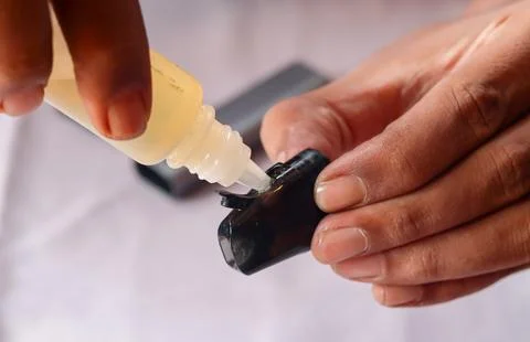 Refilling vape pod with e liquid Stock Photos